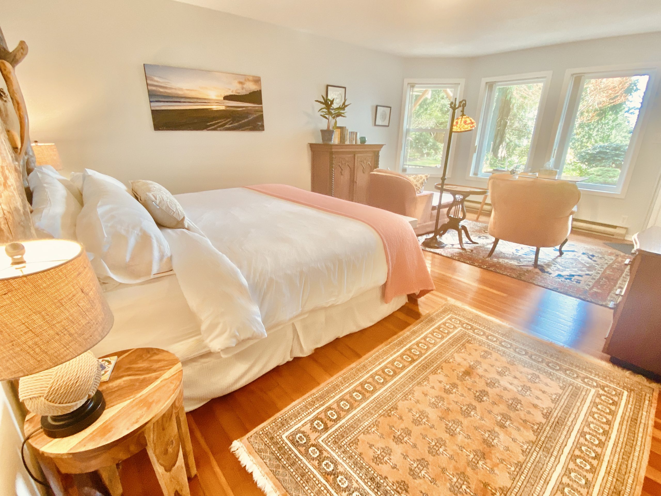 Luxury Oceanfront King Suite at Ocean Wilderness Inn featuring a handcrafted artisan headboard, private garden patio access, and panoramic views of the Salish Sea in Shirley, BC.