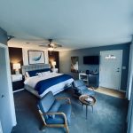 Modern Whale Watch Suite at Ocean Wilderness Inn featuring a luxury king bed, blue accents, and comfortable seating area in Shirley, BC.