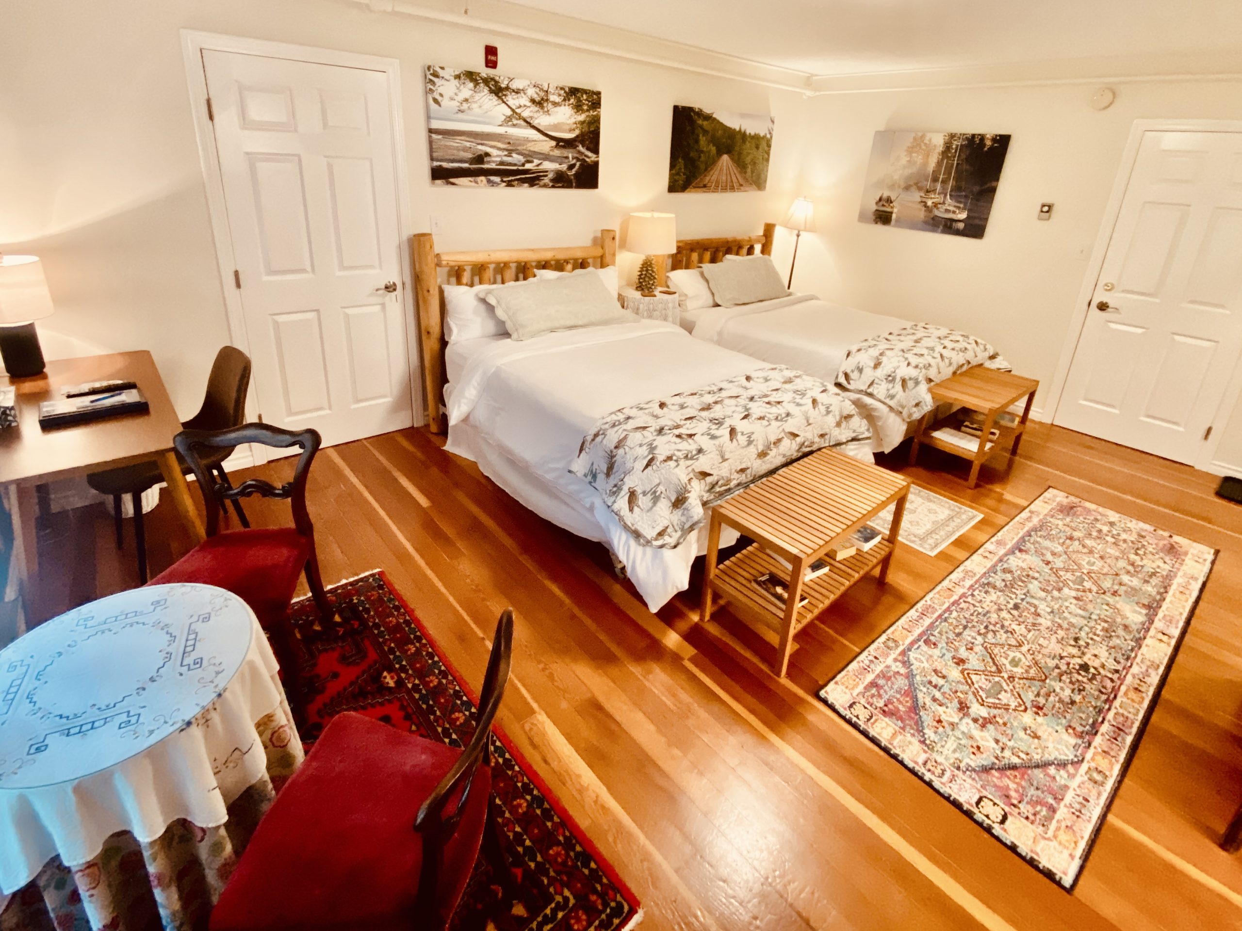 The Magic Woods Suite at Ocean Wilderness Inn featuring two double beds with luxury linens, ideal for adult groups or friends exploring Vancouver Island.