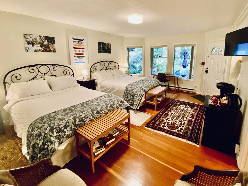 The Rainforest Suite at Ocean Wilderness Inn featuring two premium queen beds and garden-level views, ideal for adult groups or friends visiting Shirley, BC.