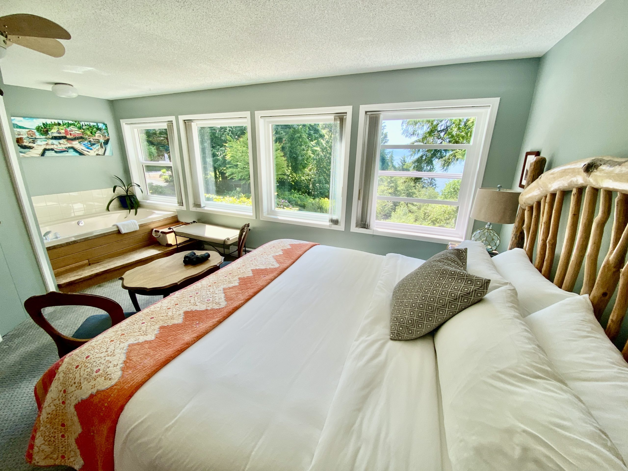 Alternative view of the Salish Sea Suite at Ocean Wilderness Inn, showing the spacious layout, luxury king bed, and large windows overlooking the Pacific coastline.