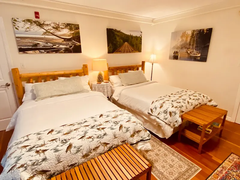 Cozy double suite bedroom at Ocean Wilderness Inn, showcasing warm lighting and vintage-inspired coastal charm in Shirley, British Columbia.