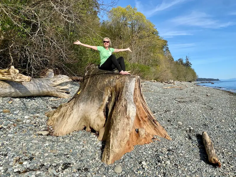 Woman enjoying beach front yoga and sunshine, at Ocean Wilderness Inn, Shirley BC