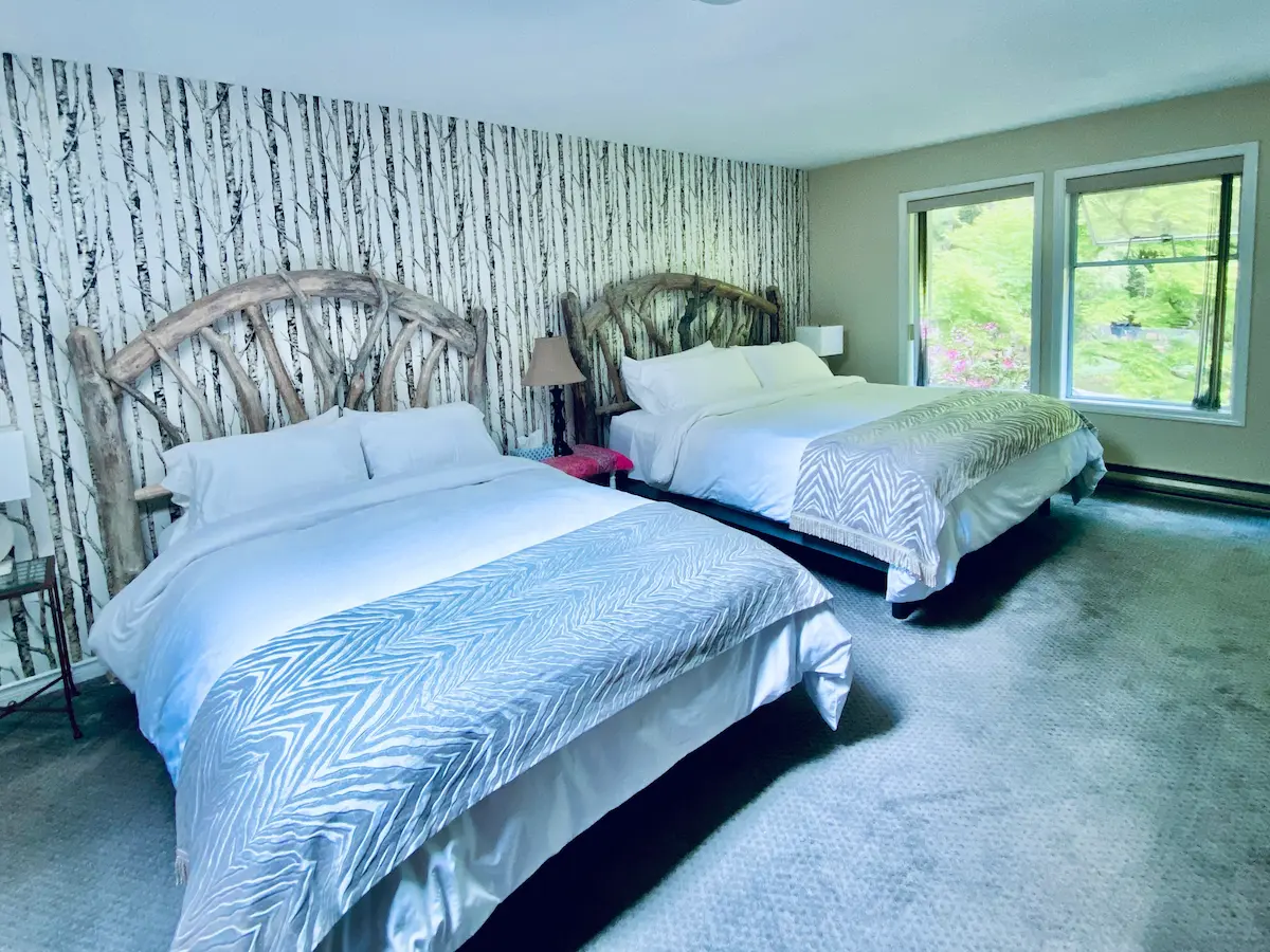 Luxury Enchanted Forest Suite at Ocean Wilderness Inn featuring hand-carved driftwood king beds and forest views in Shirley, BC.