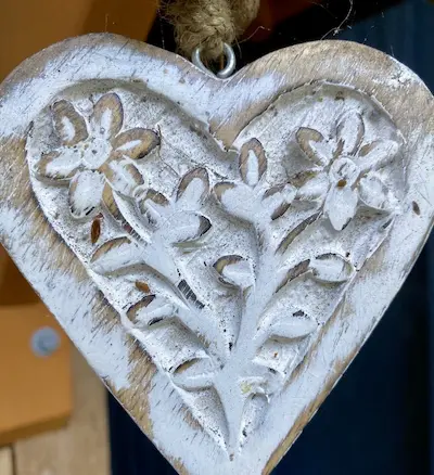 Hand-carved white wooden heart decor at Ocean Wilderness Inn, a rustic oceanfront wedding venue in Shirley, BC.