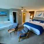 Interior view of Whale Watch Suite featuring a King bed, private seating, and ocean-facing windows.