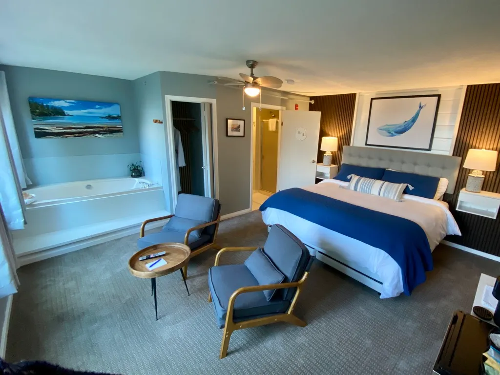 Interior view of Whale Watch Suite featuring a King bed, private seating, and ocean-facing windows.