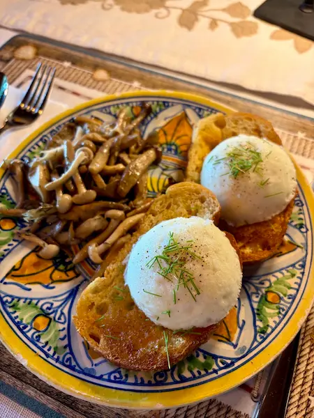 Poached farm eggs on artisan sourdough toast with sautéed wild mushrooms served for breakfast at Ocean Wilderness Inn.