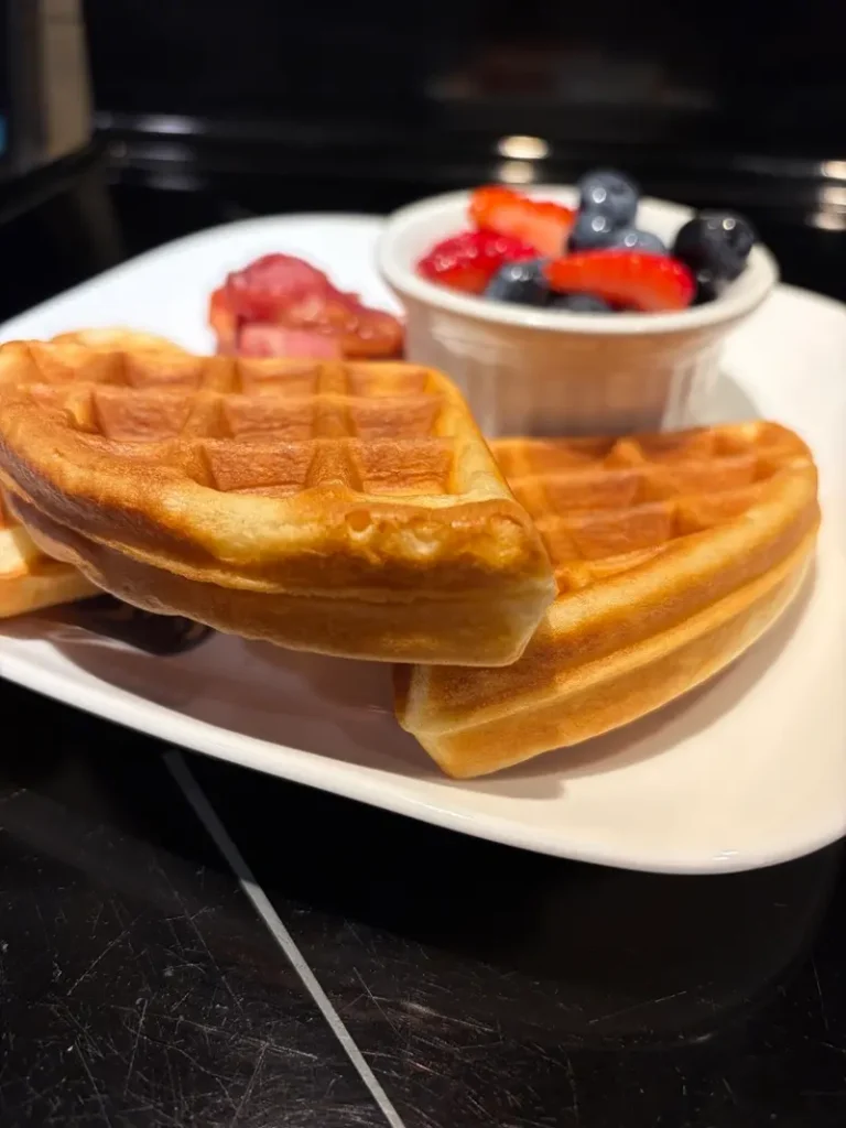 Golden Belgian waffles served with fresh berries and side dishes in the oceanfront dining room.